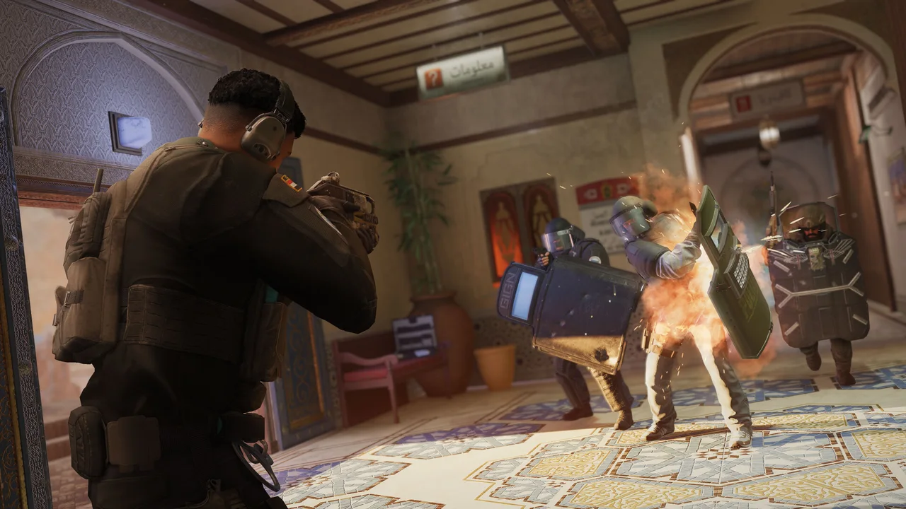 Rainbow Six Siege operators engage in a close-range firefight inside a room.