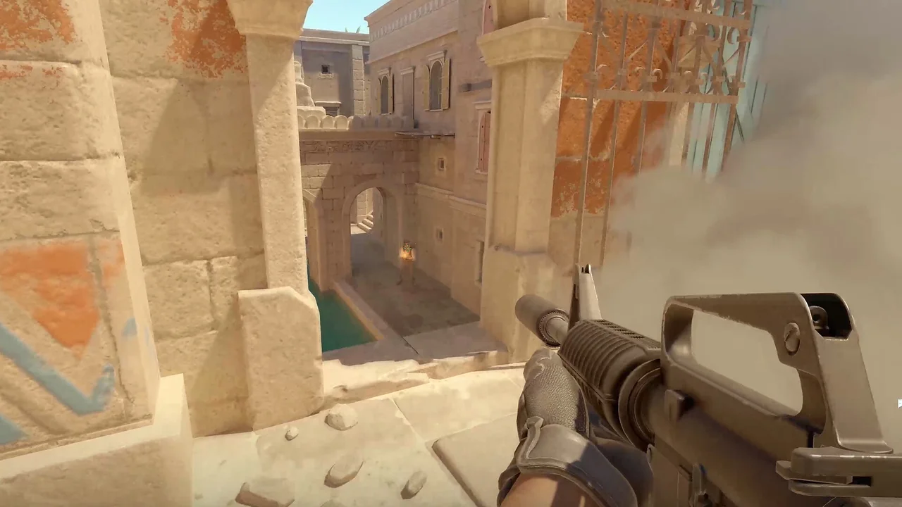A first-person Counter-Strike 2 view aims down a pale stone passage.