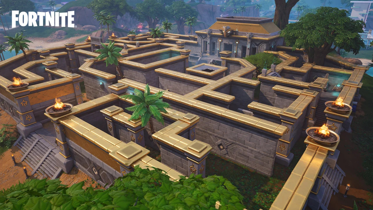 An elevated Fortnite view shows a stone courtyard with intersecting paths and palm trees.