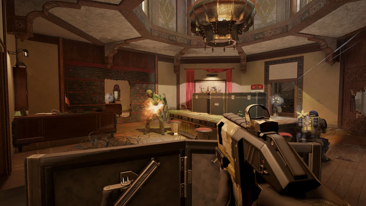 First-person Rainbow Six Siege view of a weapon aimed into a furnished room.