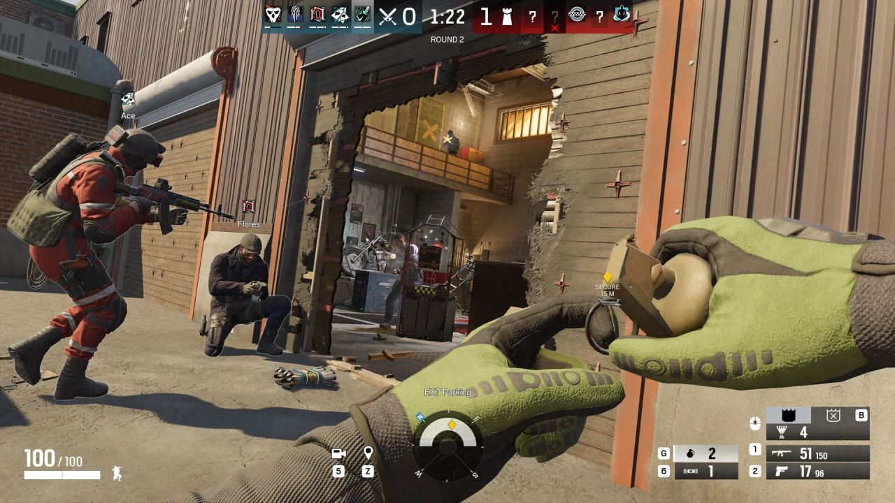 Siege teammates assemble outside a breached entrance while the player holds a gadget.